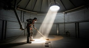 Farmer wearing safety gear while preparing a grain bin for cleaning and inspection