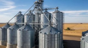 Large modern grain bin system on Midwest farm with multiple steel storage bins and concrete foundations